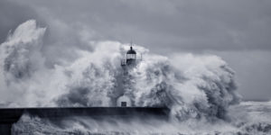 Image of waves crashing against a lighthouse